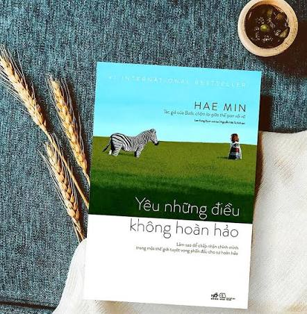 Yêu những điều không hoàn hảo by Hae Min, photographed beside wheat and a cup